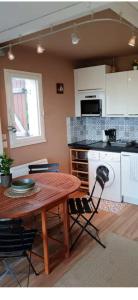 a kitchen with a wooden table and a table and chairs at Studio les pieds dans l eau in Sarzeau