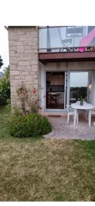 a white picnic table in front of a building at Studio les pieds dans l eau in Sarzeau