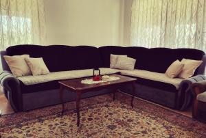a living room with a black couch and a table at Bistrički mir - Imanje in Bistrica