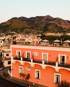 a view of a building with a mountain in the background at Hotel Nettuno in Forio d'Ischia +51 photos
