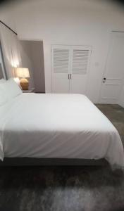 a large white bed in a white bedroom at Purevibe Horizon House Ocean View Villa Port Antonio in Port Antonio