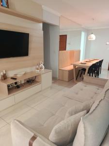 a living room with a couch and a table at Apartamento 1 km da praia com ar e garagem in Vila Velha