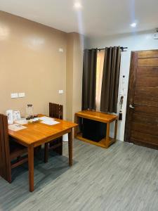 a conference room with a wooden table and a door at Tiwi's Travellers Inn - Solar Powered, Starlink, Scooter Rental, Palawan Tours in Puerto Princesa City