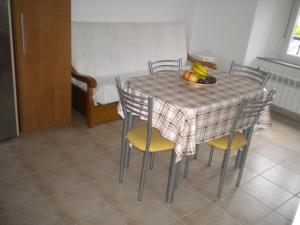a table with chairs and a bowl of fruit on it at Apartamento Ana Sebastián in Lorenzana