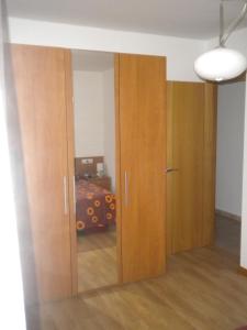 two wooden doors in a room with a bed at Apartamento Ana Sebastián in Lorenzana +6 photos