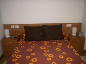a bedroom with a bed with orange flowers on it at Apartamento Ana Sebastián in Lorenzana