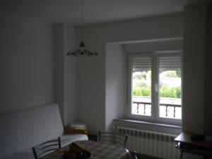 a living room with a table and a window at Apartamento Ana Sebastián in Lorenzana