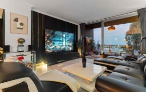 a living room with leather furniture and a large screen tv at VIP AL FATTAh LUXURY in Estepona