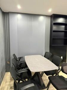 a meeting room with a table and black chairs at YourHome - Stay & More in Hoàng Mai