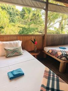 two beds in a room with a window at Lodge El Amargal - Reserva Natural, Ecoturismo & Surf in Nuquí