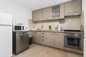 a kitchen with stainless steel appliances and white cabinets at Casa Dava in Râşnov +36 photos