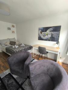 a living room with a bed and a desk and chairs at BR Apartment in Kiel
