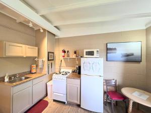 a kitchen with a white refrigerator and a table at #02 - Unique Lakeside Studio Cottage- Pet Friendly in Hot Springs +14 photos