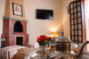 a tea kettle on a table in a room with a fireplace at Villa Dar Nata in Tougouana