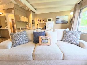 a white couch with pillows in a living room at #02 - Unique Lakeside Studio Cottage- Pet Friendly in Hot Springs