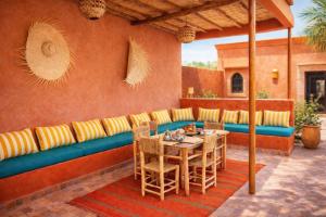 a patio with a couch and a table and chairs at Villa Dar Nata in Tougouana