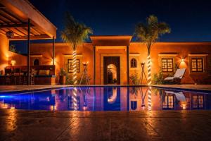 a house with a swimming pool at night at Villa Dar Nata in Tougouana