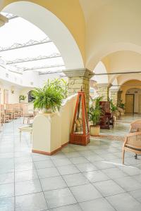 a lobby with tables and chairs and plants at Hotel Nettuno in Forio d'Ischia