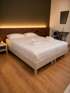 a large bed with two towels on it in a bedroom at Colombo Central Apartment in Garda