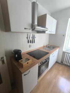 a kitchen with white cabinets and a sink and a stove at BR Apartment in Kiel