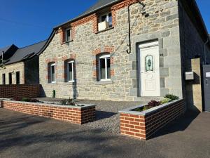 a brick building with a white door on it at Au charme d'antan in Féron