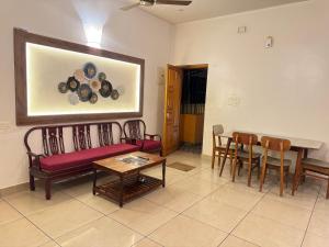 a living room with a couch and a table and chairs at Villa Shakti - TIE Hotels in Pondicherry