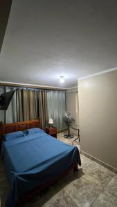 a bedroom with a blue bed and a window at Hospedaje SAUNA & SPA NOAH in Bagua Grande