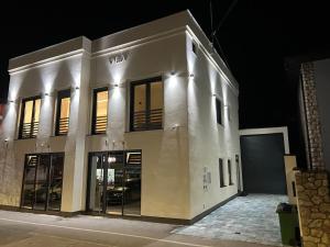 a large white building with a garage at night at Hostel N&N in Kula