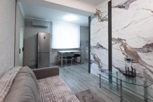 a living room with a couch and a marble wall at Apartaments Miro in Chişinău