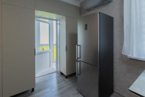 a stainless steel refrigerator in a room with a window at Apartaments Miro in Chişinău