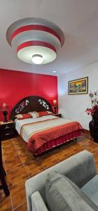 a bedroom with a large bed and a red wall at El Tesoro de Arturo in Tilapa