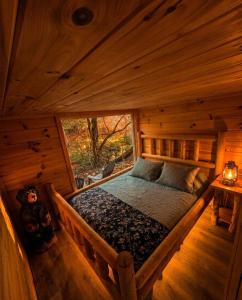 a bedroom with a bed in a wooden cabin at Meadowview Springs in Louisville