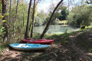 three canoes sitting on the side of a river at Meadowview Springs in Louisville