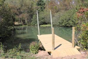 a wooden dock in the middle of a river at Meadowview Springs in Louisville +4 photos