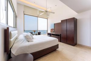 a bedroom with a bed and a large window at 1083 - Cosmo 3A3 in Tangolunda +27 photos