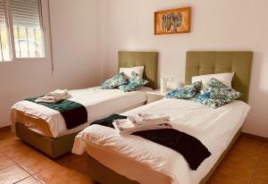 a bedroom with two beds with towels on them at Casa Verdejo in Cómpeta +10 photos