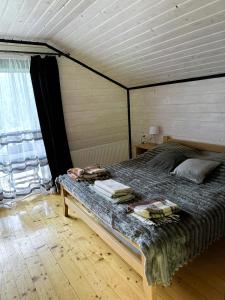 a bed in a room with a wooden ceiling at Котедж Ксенія in Dzembronya