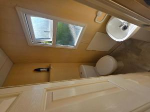 a small bathroom with a toilet and a window at Twin Ayre Cabin Retreat Welshpool in Welshpool +12 photos