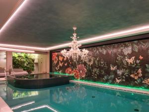 a swimming pool in a house with a wall mural at Asiago Sporting Hotel & SPA - Buongiorno! Hotels in Asiago +32 photos