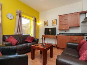 a living room with a couch and a table at Farriers Cottage in Bridlington