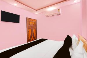 a bedroom with a bed and a door at Hotel O Sky House Residency in New Delhi