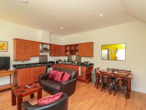a kitchen and living room with a couch and a table at Farriers Cottage in Bridlington