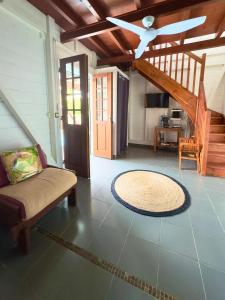 a living room with a couch and a ceiling fan at Lili bungalows in Capesterre