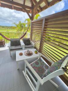 a patio with two chairs and a table on a deck at Lili bungalows in Capesterre