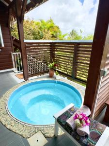 a hot tub on a deck with a patio at Lili bungalows in Capesterre