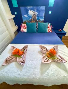 two towels on a bed with a windmill in the background at Lili bungalows in Capesterre +38 photos