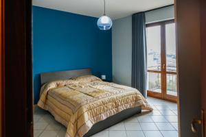a blue bedroom with a bed and a window at ll Paiolo Magico in Montella