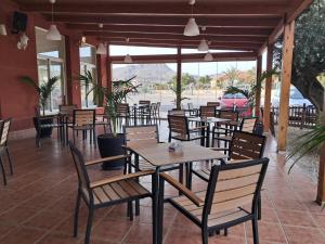 a restaurant with tables and chairs and a car at Hotel venta de Tébar in Águilas