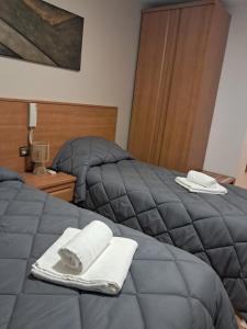 two beds with towels on top of them in a bedroom at Hotel venta de Tébar in Águilas