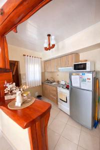 a kitchen with a refrigerator and a table in it at Apart Hotel Rústicos Valentina in Dolores +12 photos